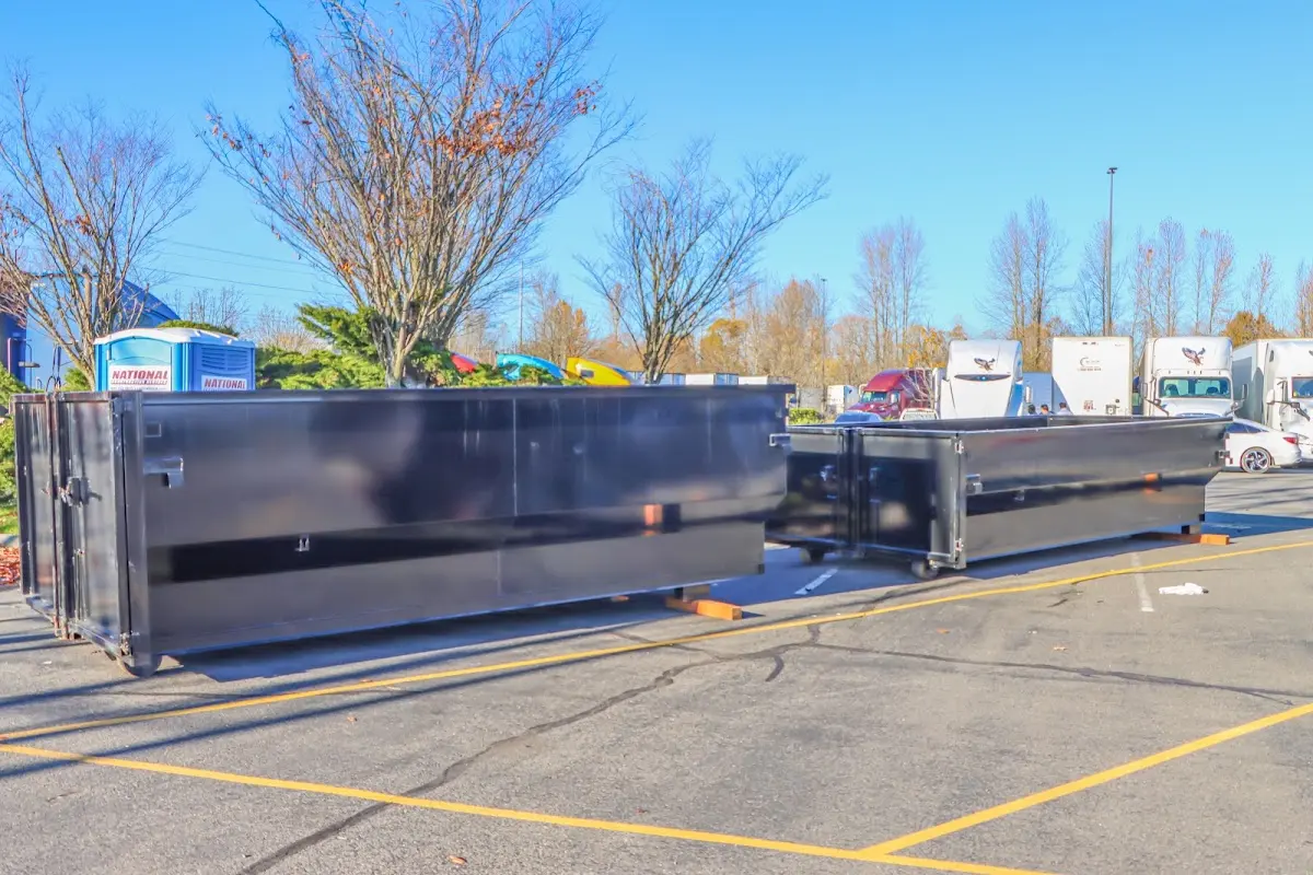 Professional dumpster rental service with roll-off container on residential driveway in Pullman